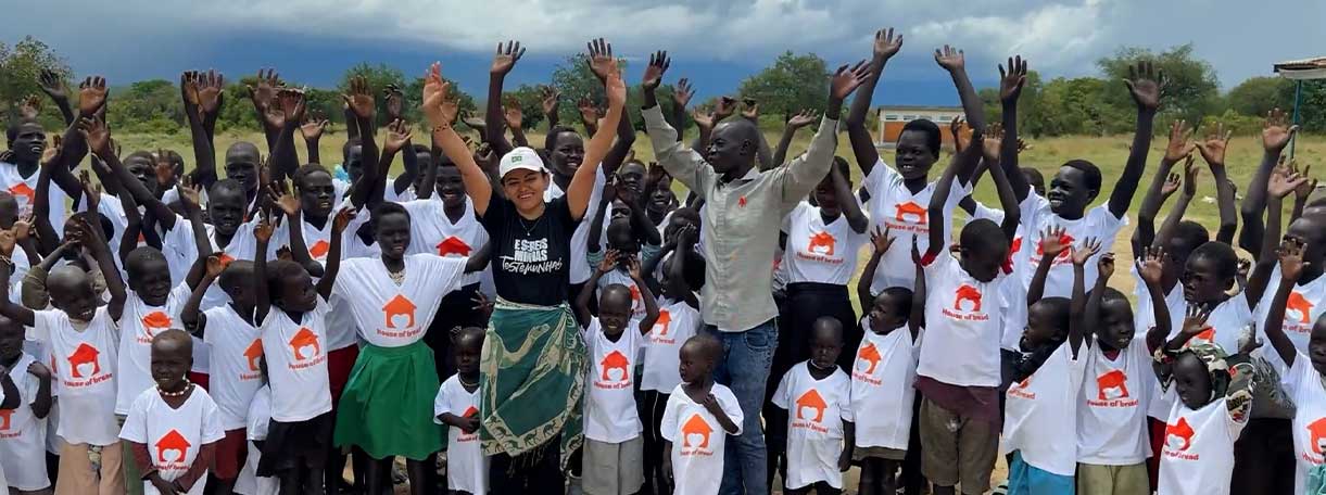 Crianças do projeto Casa de Pão com braços levantados