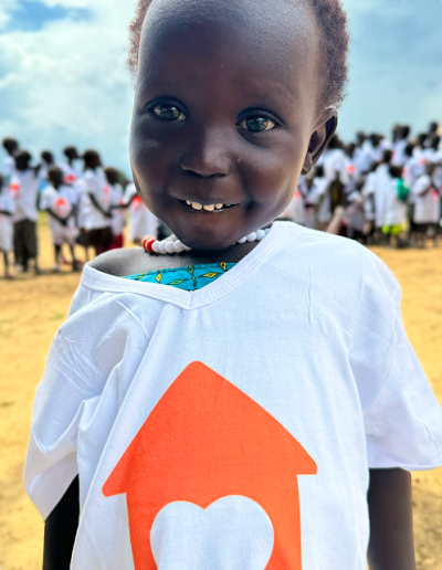 Criança sorrindo com camiseta do projeto